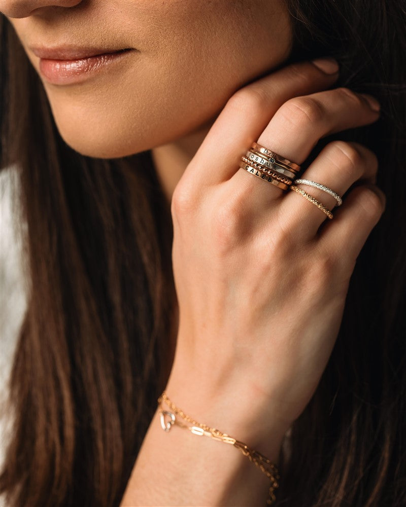 a set of gold and silver rings on a woman's hand 