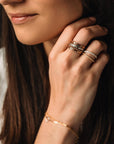 a set of gold and silver rings on a woman's hand 