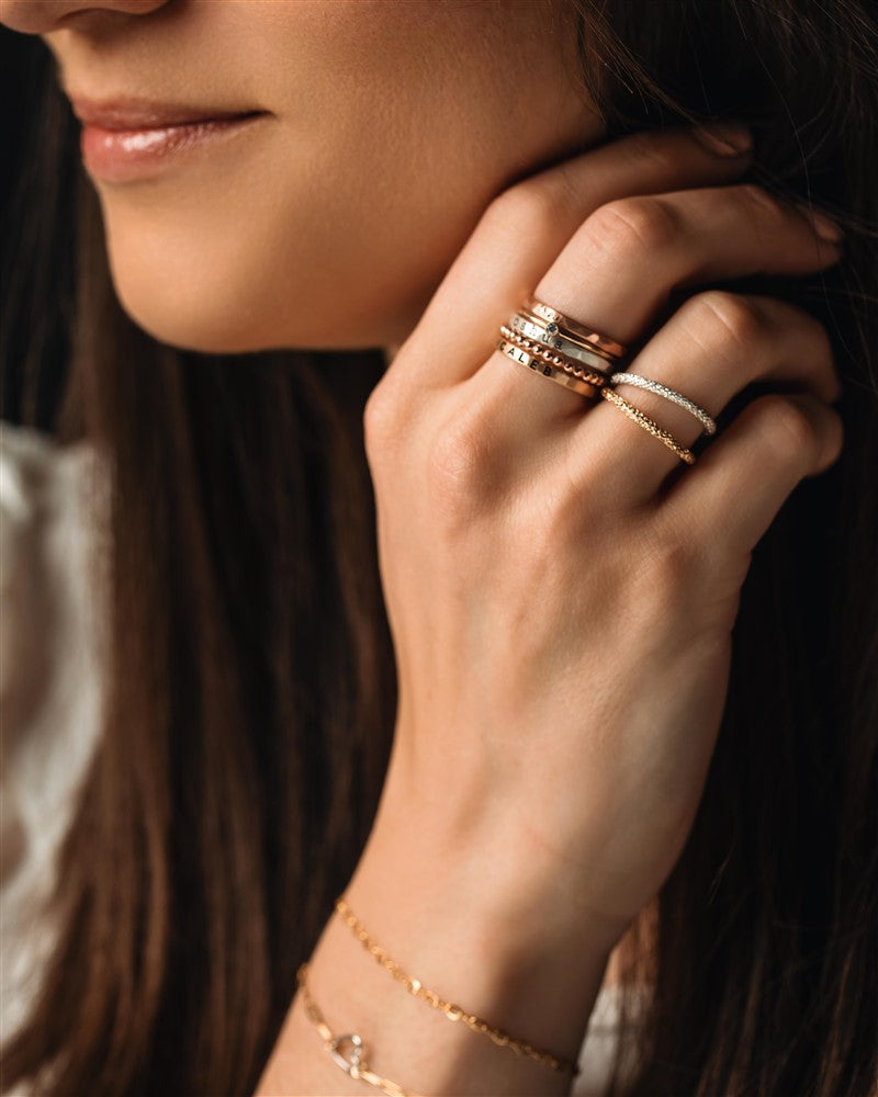 silver and gold rings and bracelets on a woman&#39;s hand