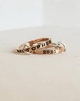 Two rose gold rings with engraved text on a light background