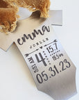 Engraved baby stats ornament with taupe ribbon shown from side angle