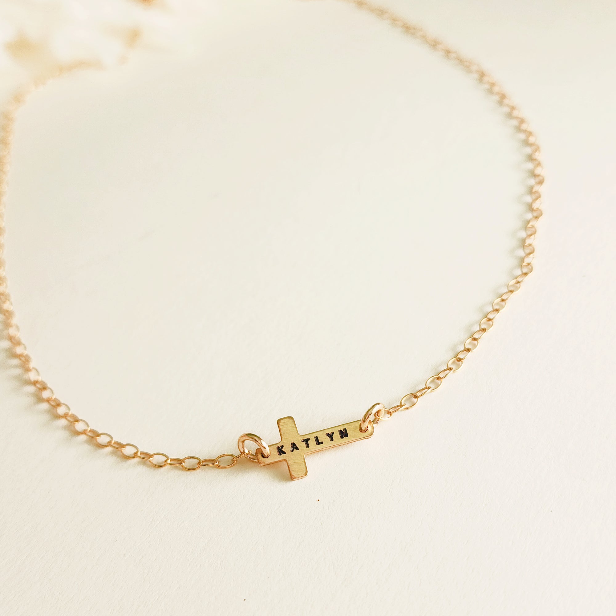 14K gold-filled personalized cross necklace engraved with the name Katlyn displayed on white background