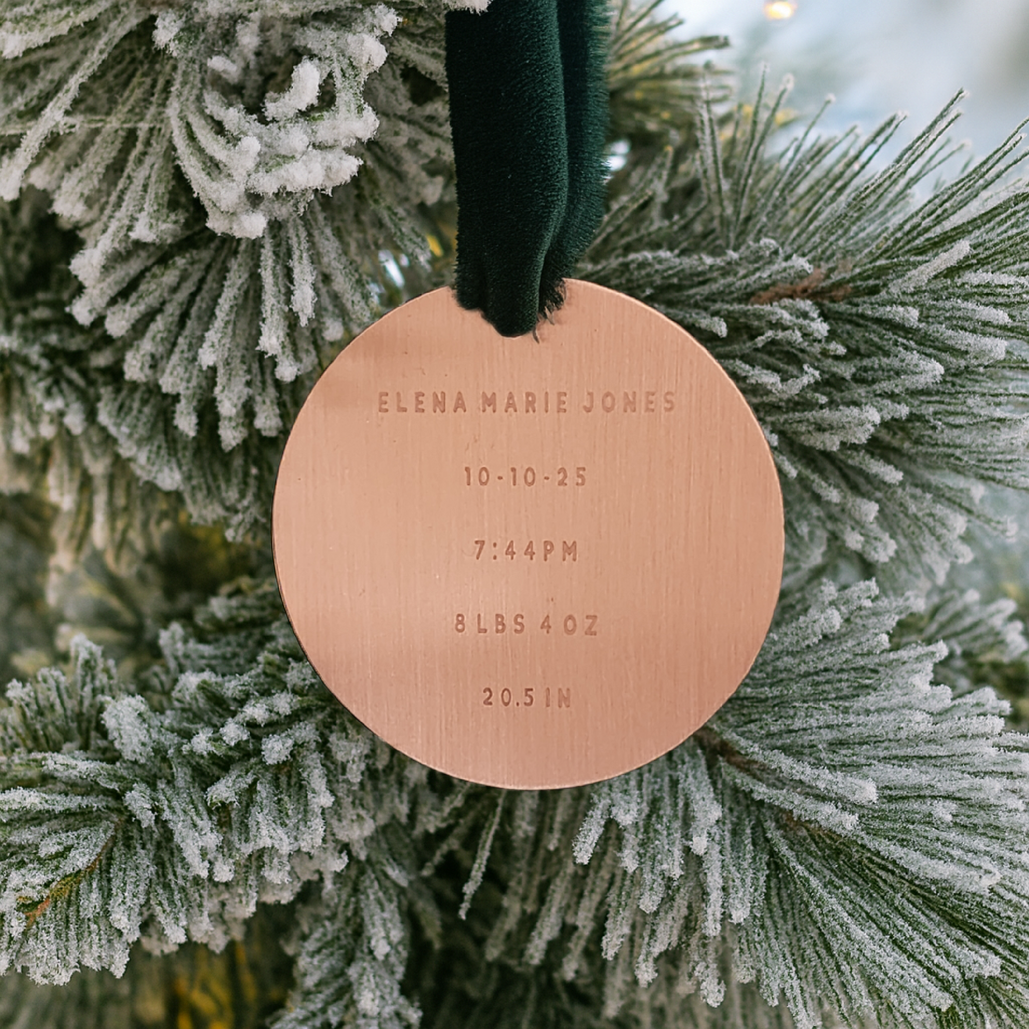 Round copper ornament with engraved text on a Christmas tree