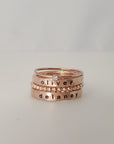 A set of stacked silver rings, with one ring engraved with the name 'OLIVER' and another with 'DELANEY'. The set includes a ring with a small diamond at the top, and a beaded spacer ring.