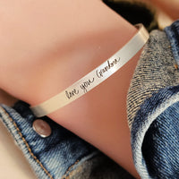 silver cuff bracelet on arm stating love you grandma