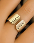 Gold ring with 'Cleo' and 'ELOISE' engraved on a finger