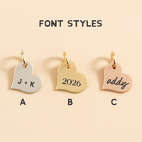 Three heart-shaped charms with different font styles on a beige background