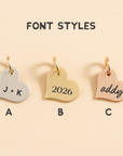Three heart-shaped charms with different font styles on a beige background
