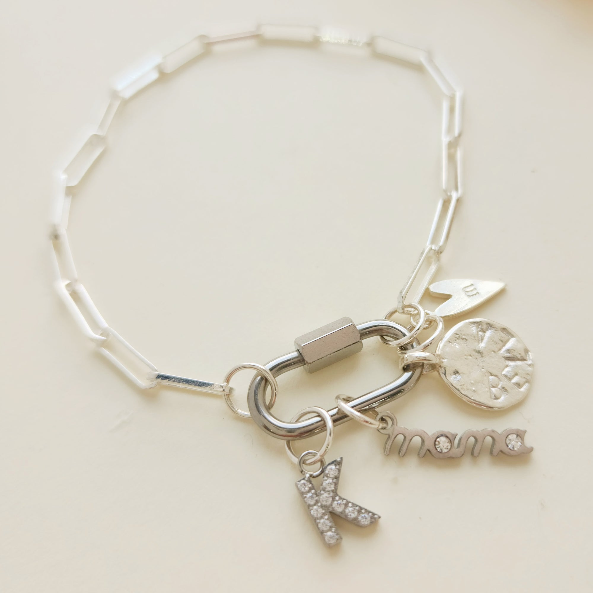 Silver bracelet with charms on a light beige background