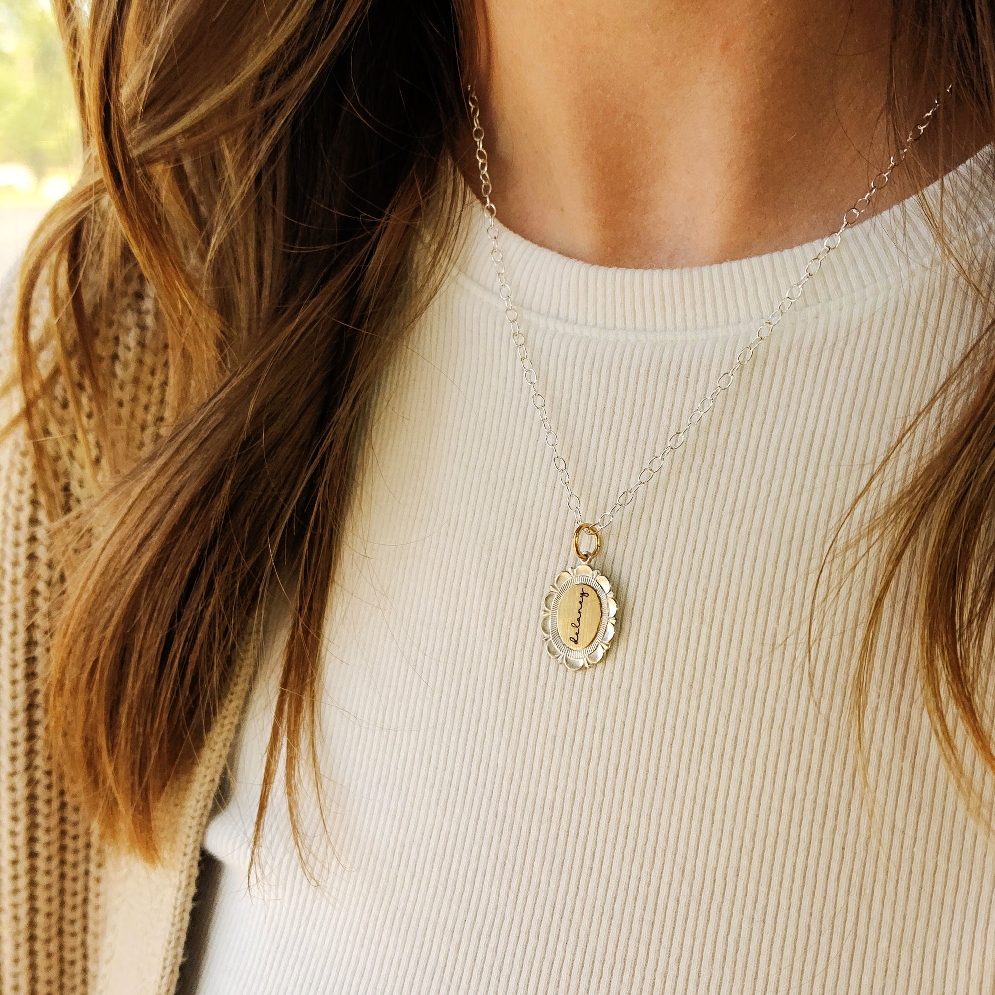 Close-up of a person wearing a gold necklace with a pendant.
