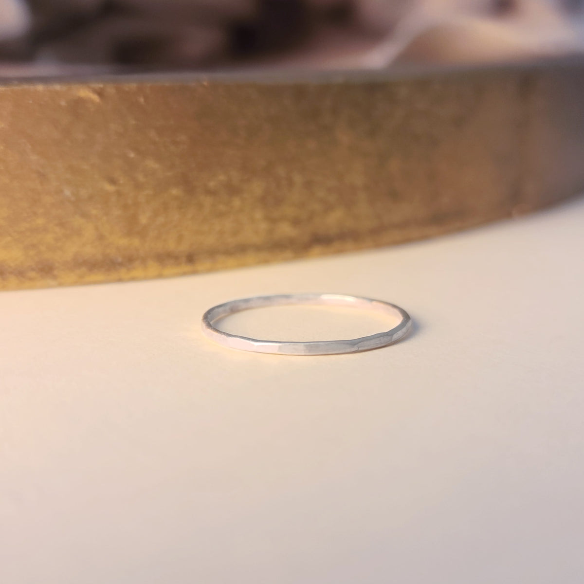 Thin silver ring on a light background