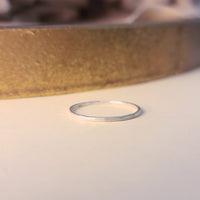 Thin silver ring on a light background