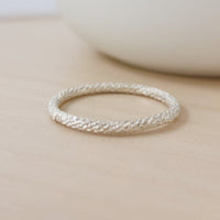 a sterling silver sparkle ring on a tan background