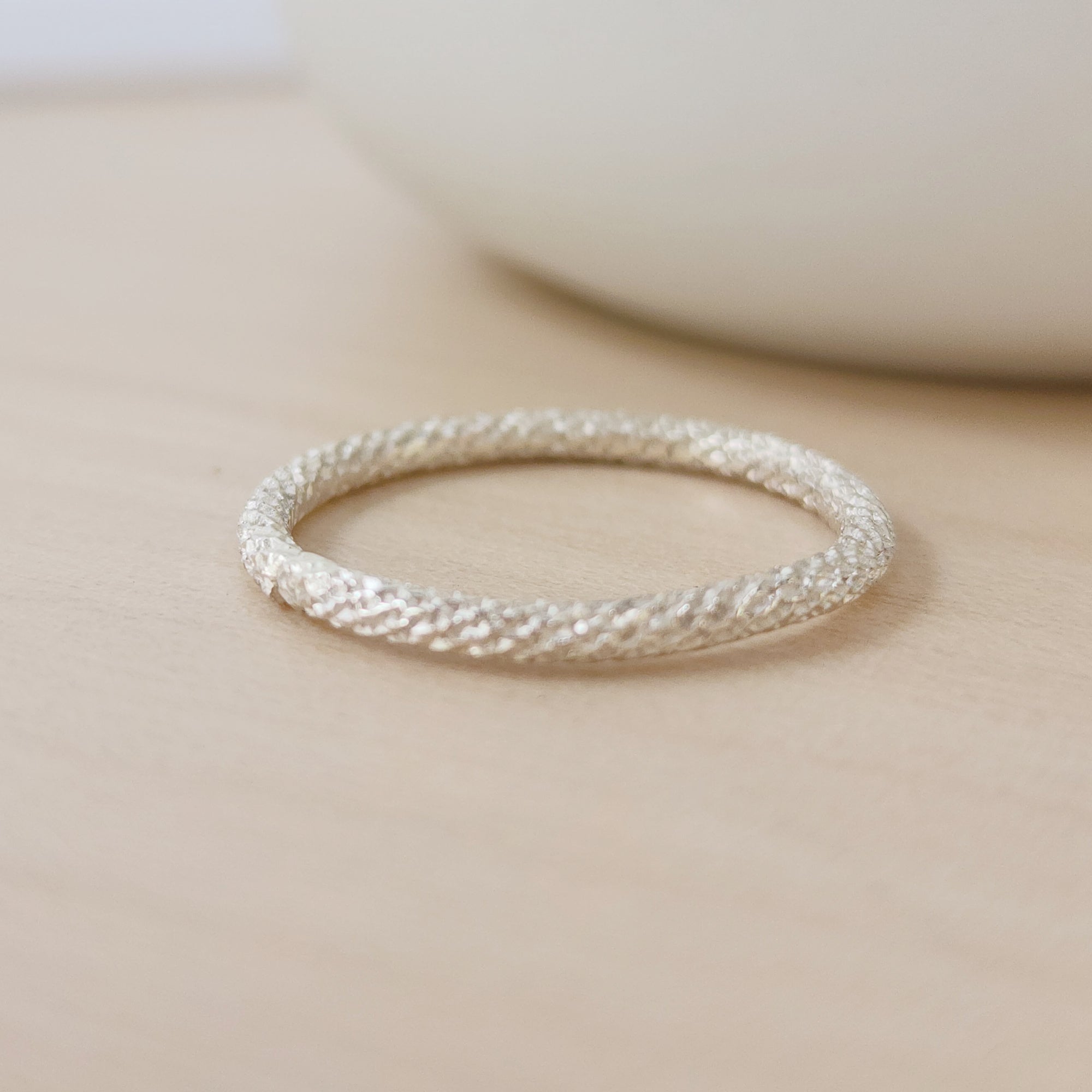 a sterling silver sparkle ring on a tan background