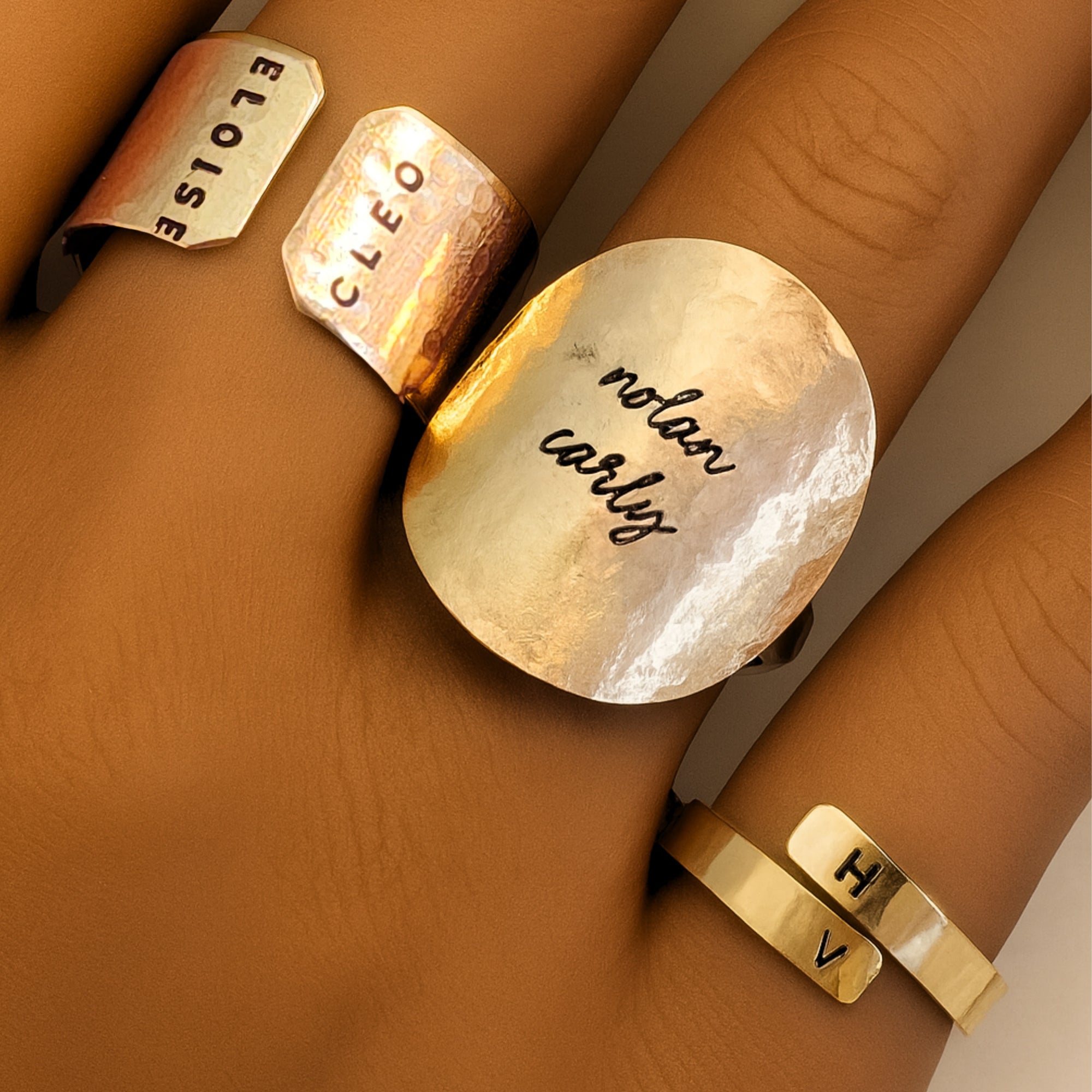 Stacked gold personalized rings including cuff and hammered disc designs