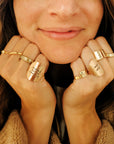Woman wearing stacked personalized gold name rings handmade by Going Golden